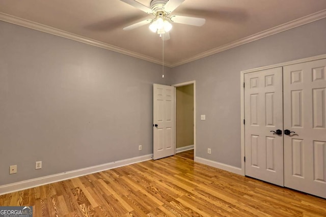 unfurnished bedroom featuring light wood-style flooring, a ceiling fan, a closet, baseboards, and ornamental molding