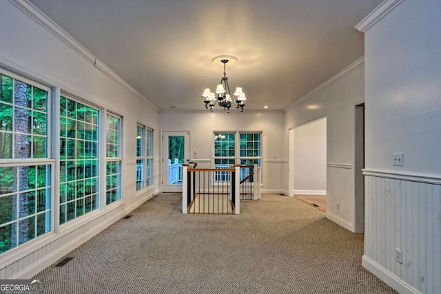 interior space featuring crown molding, a wainscoted wall, visible vents, and an inviting chandelier