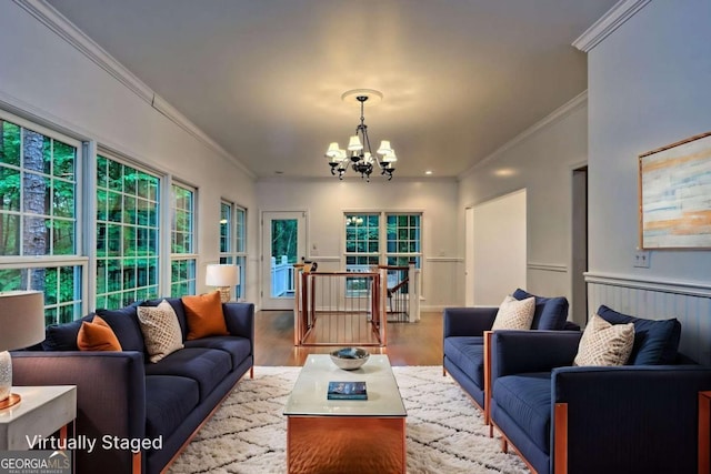living area with a notable chandelier, crown molding, and wood finished floors