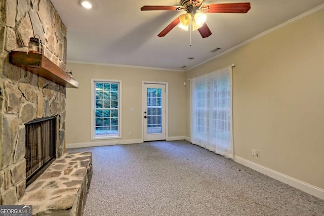unfurnished living room featuring carpet, baseboards, a stone fireplace, visible vents, and crown molding