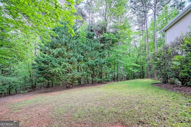view of yard featuring a forest view