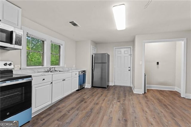 1939 Dunlap Ave, Atlanta, GA 30344 - kitchen with stainless steel appliances, visible vents, a sink, light countertops, and white cabinets