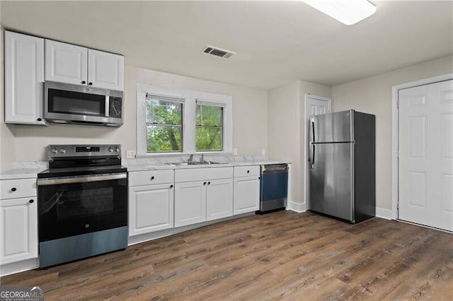 1939 Dunlap Ave, Atlanta, GA 30344 - kitchen with white cabinets, light countertops, stainless steel appliances, and visible vents