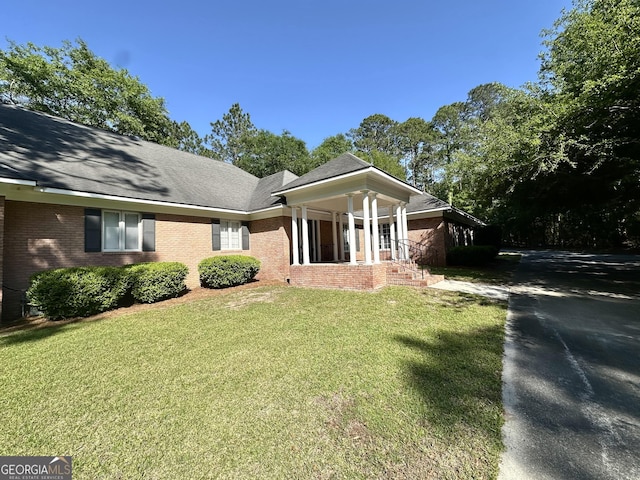 greek revival house with brick siding and a front yard