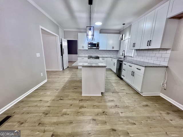 kitchen featuring black dishwasher, stainless steel microwave, baseboards, decorative backsplash, and ornamental molding