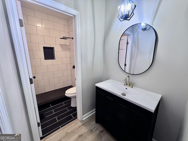 full bathroom featuring vanity, toilet, a shower, and wood finished floors