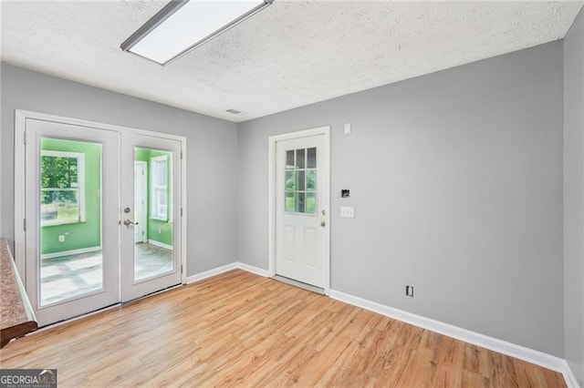 3880 Dial Mill Rd NE, Conyers, GA 30013 - entryway with light wood-style flooring, a textured ceiling, baseboards, and french doors