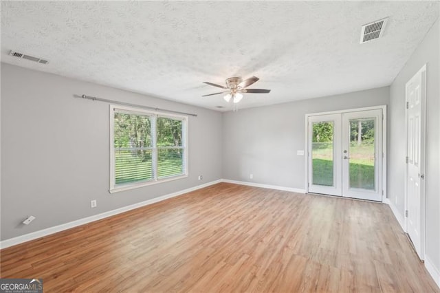 3880 Dial Mill Rd NE, Conyers, GA 30013 - spare room featuring ceiling fan, light wood finished floors, baseboards, french doors, and a textured ceiling