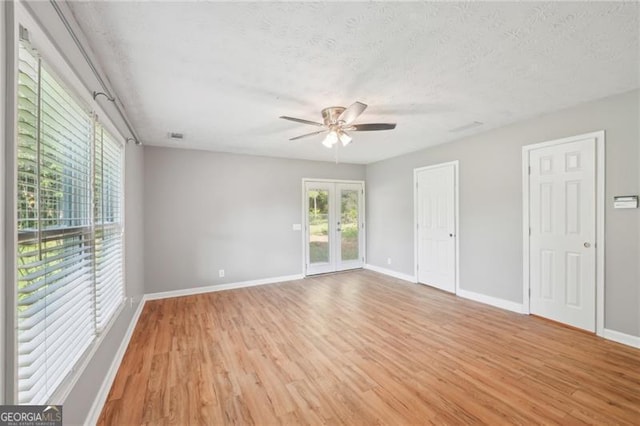 3880 Dial Mill Rd NE, Conyers, GA 30013 - spare room featuring a ceiling fan, healthy amount of natural light, light wood-type flooring, baseboards, and a textured ceiling