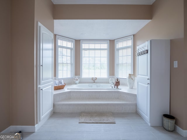 bathroom with tile patterned floors, a garden tub, and baseboards
