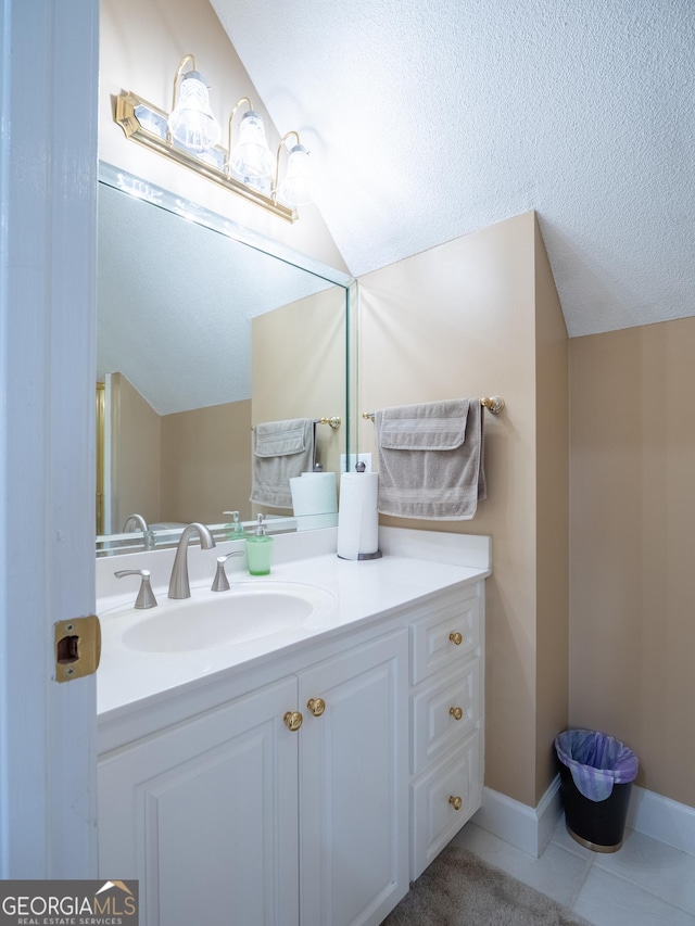 bathroom featuring lofted ceiling, tile patterned flooring, vanity, and baseboards