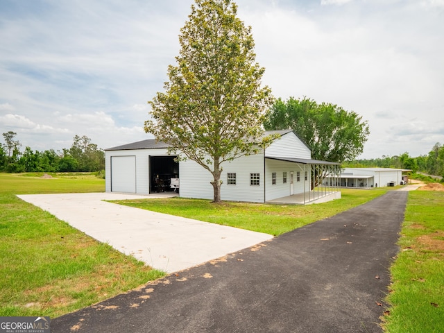 view of front of house with an outdoor structure, a front lawn, and a garage