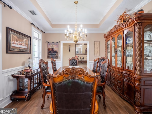 dining area with visible vents, wood finished floors, a raised ceiling, and a notable chandelier