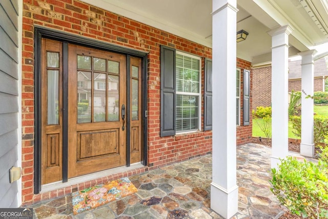 3016 Levinshire Way, Dacula, GA 30019 - doorway to property featuring covered porch and brick siding