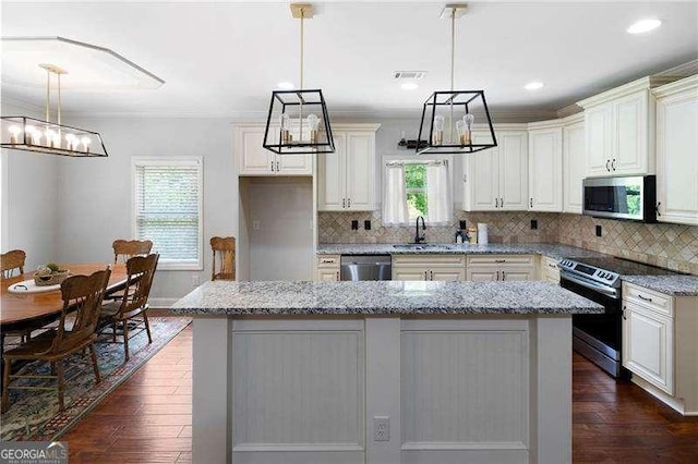 42 Treemont Dr SE, Cartersville, GA 30121 - kitchen with stainless steel appliances, a chandelier, dark wood-style floors, a center island, and light stone countertops