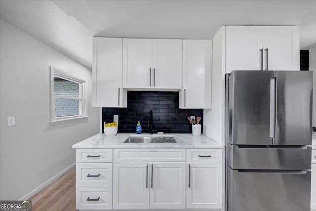 3807 Greenhill Dr, Chamblee, GA 30341 - kitchen with freestanding refrigerator, white cabinets, light wood-type flooring, and decorative backsplash