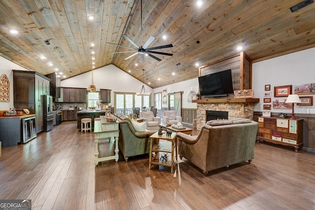 living area with beverage cooler, a fireplace, visible vents, dark wood-style flooring, and ceiling fan