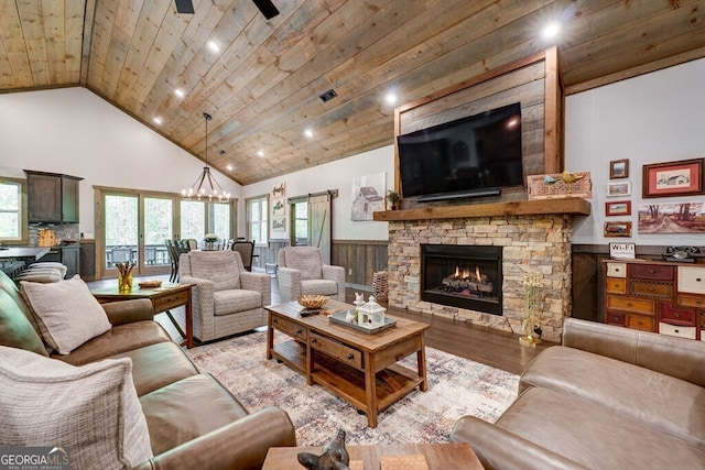 living room with wood ceiling, high vaulted ceiling, a wainscoted wall, wood finished floors, and a fireplace