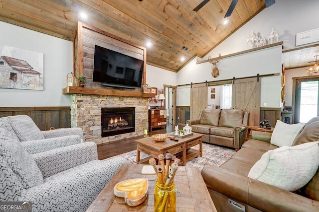 living room with wooden ceiling, a barn door, a wainscoted wall, and wood finished floors
