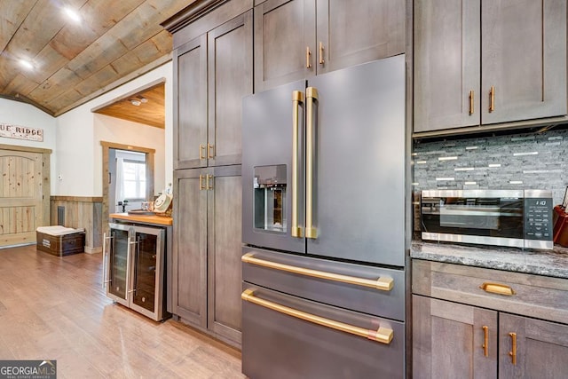 kitchen featuring wine cooler, light wood-type flooring, wainscoting, wood ceiling, and appliances with stainless steel finishes