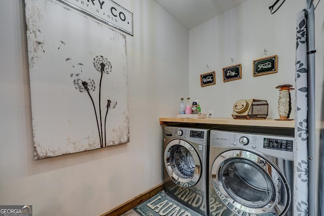 laundry room featuring washing machine and clothes dryer, baseboards, laundry area, and wood finished floors
