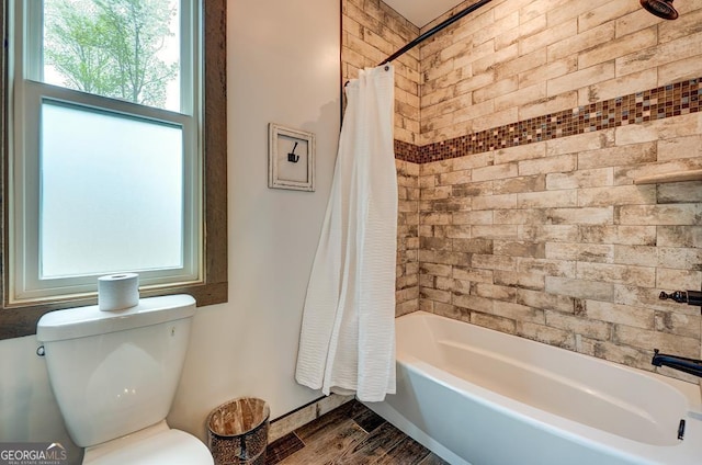 bathroom featuring toilet, shower / bathtub combination with curtain, and wood finished floors