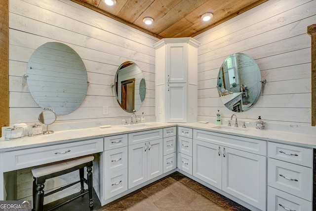 bathroom with double vanity, wooden ceiling, wooden walls, and a sink