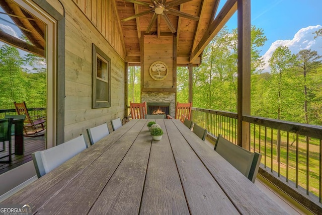wooden terrace with a fireplace and ceiling fan