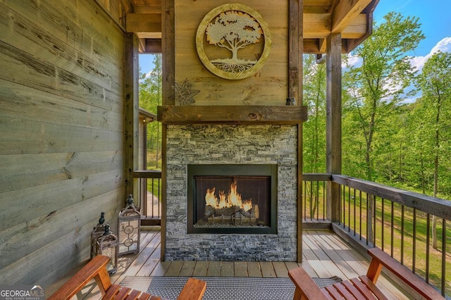 deck with an outdoor stone fireplace