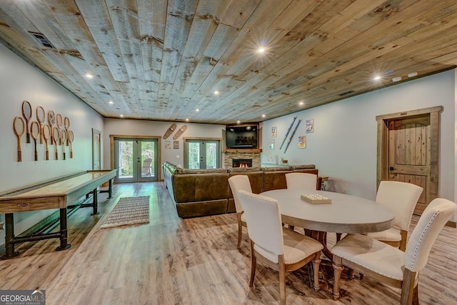 dining area with a fireplace, recessed lighting, french doors, and wood finished floors