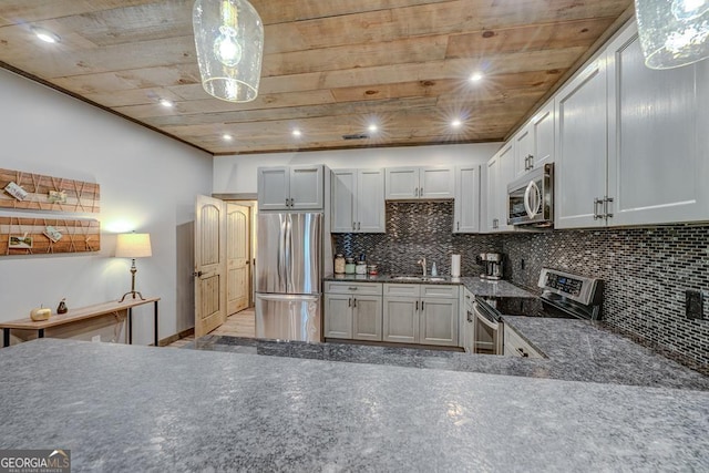 kitchen featuring dark stone countertops, a sink, appliances with stainless steel finishes, backsplash, and wooden ceiling