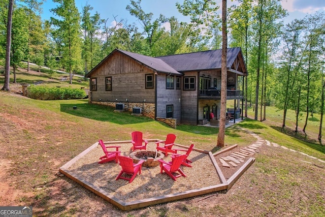 rear view of house with an outdoor fire pit, a yard, a patio area, and a deck
