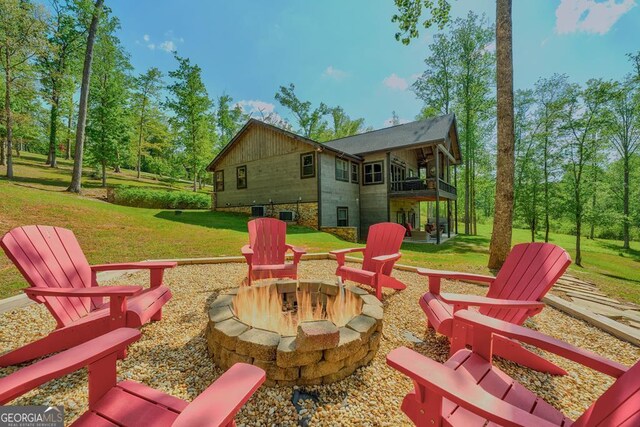 exterior space featuring an outdoor fire pit and a balcony