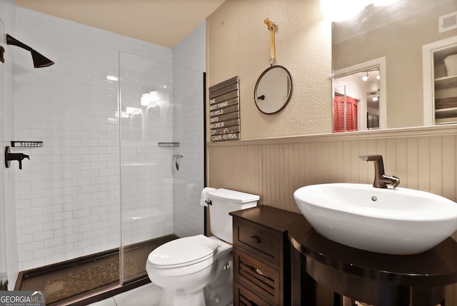 401 N Cromwell Rd Unit 6K, Savannah, GA 31410 - full bathroom featuring wainscoting, toilet, a sink, and a stall shower