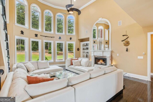 3364 Kylee Dawn Cir, Lawrenceville, GA 30045 - living area featuring a lit fireplace, a towering ceiling, dark wood-type flooring, and visible vents
