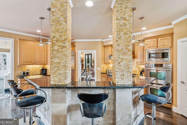3364 Kylee Dawn Cir, Lawrenceville, GA 30045 - kitchen featuring stainless steel appliances, ornate columns, backsplash, a kitchen bar, and crown molding