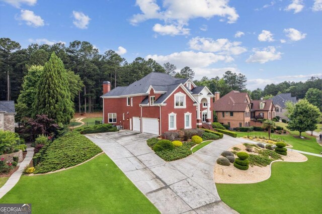 3364 Kylee Dawn Cir, Lawrenceville, GA 30045 - view of front of property with a chimney, driveway, brick siding, a garage, and a front yard