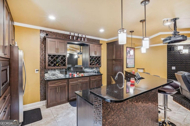 3364 Kylee Dawn Cir, Lawrenceville, GA 30045 - kitchen with a breakfast bar area, crown molding, backsplash, dark stone countertops, and dark brown cabinetry