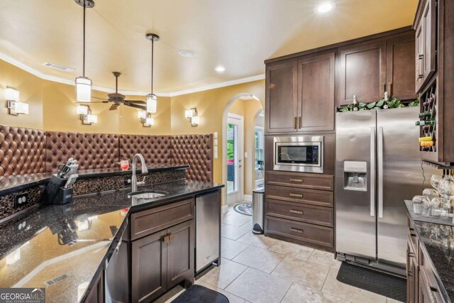 3364 Kylee Dawn Cir, Lawrenceville, GA 30045 - kitchen featuring a sink, ceiling fan, dark brown cabinetry, arched walkways, and appliances with stainless steel finishes