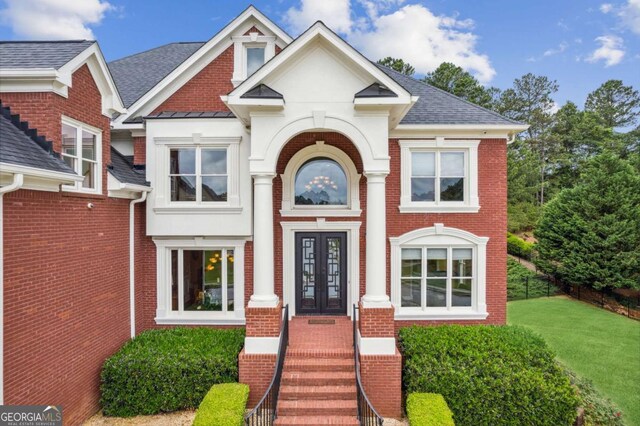 3364 Kylee Dawn Cir, Lawrenceville, GA 30045 - view of front facade featuring a standing seam roof, brick siding, french doors, a front yard, and roof with shingles