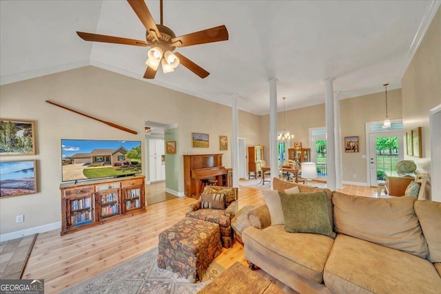 living area with baseboards, decorative columns, ceiling fan with notable chandelier, a towering ceiling, and wood finished floors