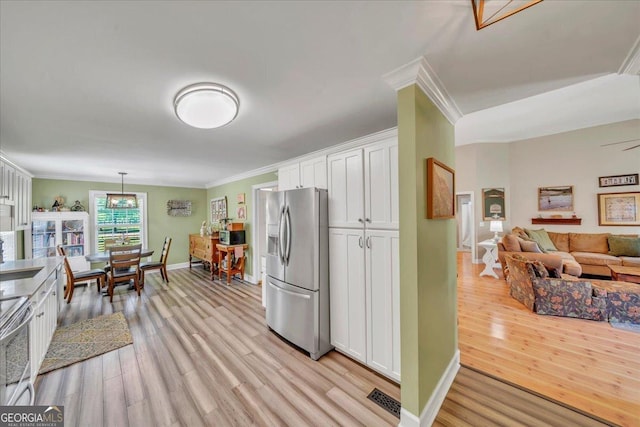 kitchen featuring stainless steel appliances, crown molding, light wood finished floors, white cabinetry, and baseboards