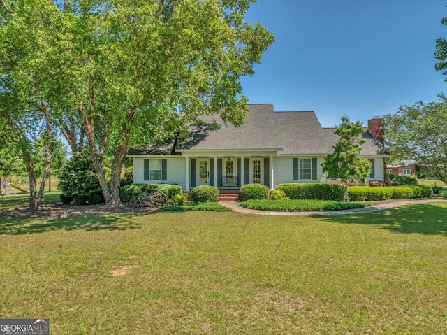 view of front of home with a front lawn, a porch, and a chimney