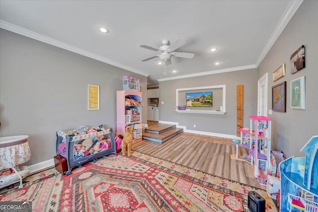 recreation room with crown molding, wood finished floors, baseboards, and recessed lighting