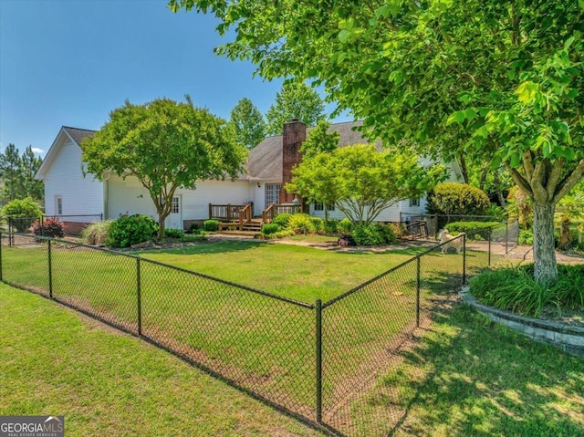 view of yard with a wooden deck and a fenced backyard