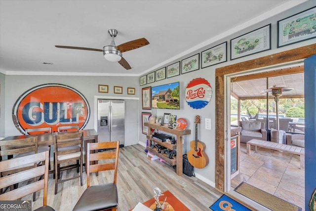 interior space featuring ornamental molding, baseboards, and a ceiling fan