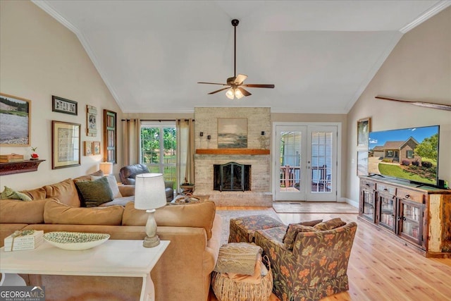 living area with a ceiling fan, baseboards, ornamental molding, light wood finished floors, and a fireplace