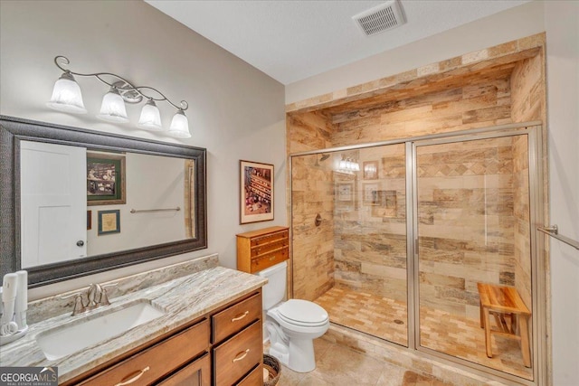 full bathroom featuring toilet, visible vents, a shower stall, tile patterned flooring, and vanity