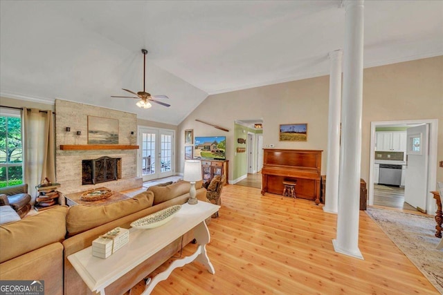 living area featuring ceiling fan, light wood finished floors, plenty of natural light, and decorative columns