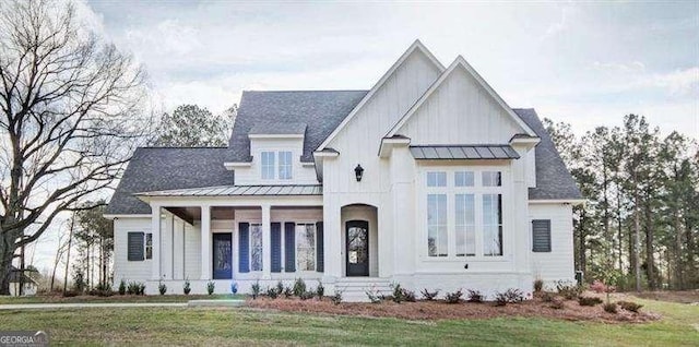 view of front of house with a front yard, board and batten siding, metal roof, and a standing seam roof